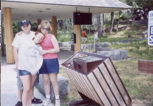 Family posing with a bear-proof garbage can at Acadia National Park